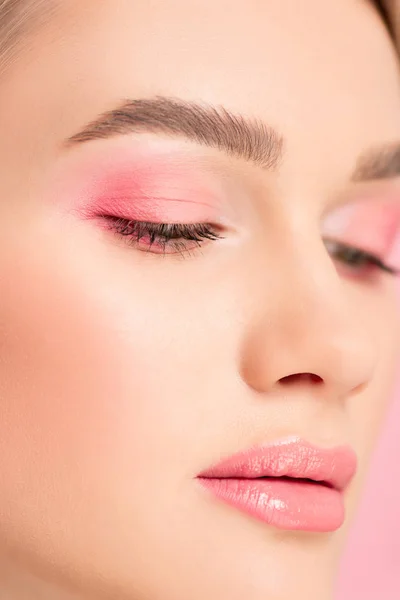 Nahaufnahme eines attraktiven Mädchens mit rosa Make-up, isoliert auf rosa — Stockfoto