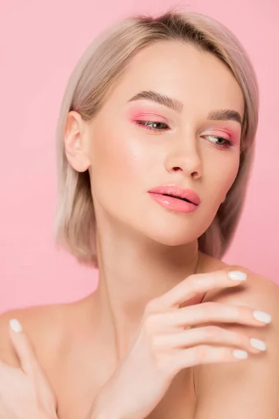 Atractiva mujer tierna con maquillaje rosa, aislado en rosa - foto de stock