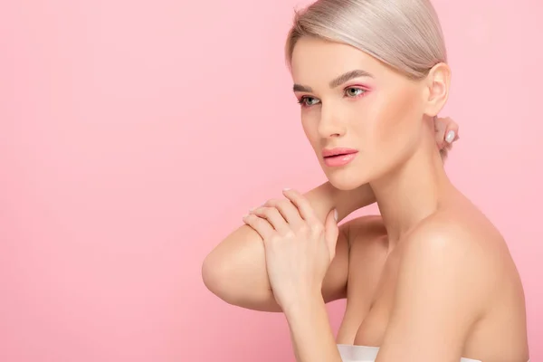 Schöne blonde Mädchen mit rosa Make-up, isoliert auf rosa — Stockfoto