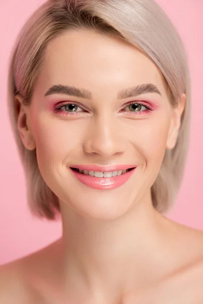 Веселая привлекательная девушка с розовым макияжем, изолированные на розовый — стоковое фото