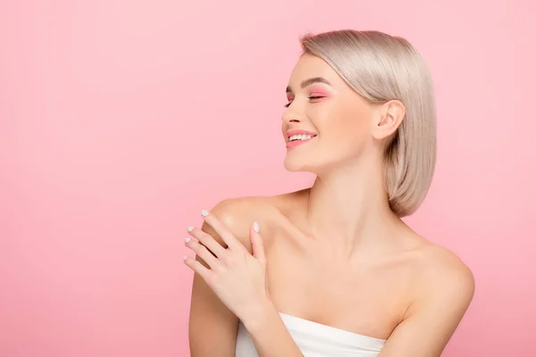 Hermosa chica positiva con maquillaje rosa, aislado en rosa - foto de stock