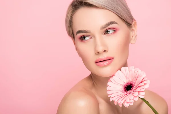 Schönes Mädchen mit rosa Make-up und Gerbera-Blume, isoliert auf rosa — Stockfoto