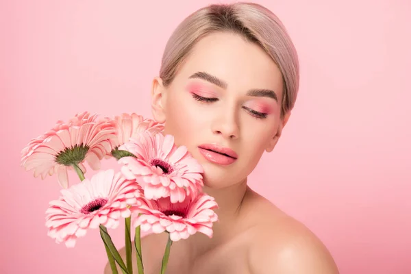 Hermosa chica desnuda con flores de gerberas rosa, aislado en rosa - foto de stock