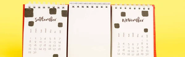 Panoramic shot of calendar with autumn months and empty blank on yellow background — Stock Photo