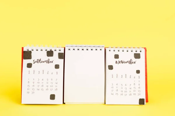 Calendario con los meses de septiembre y noviembre y vacío en blanco sobre fondo amarillo - foto de stock