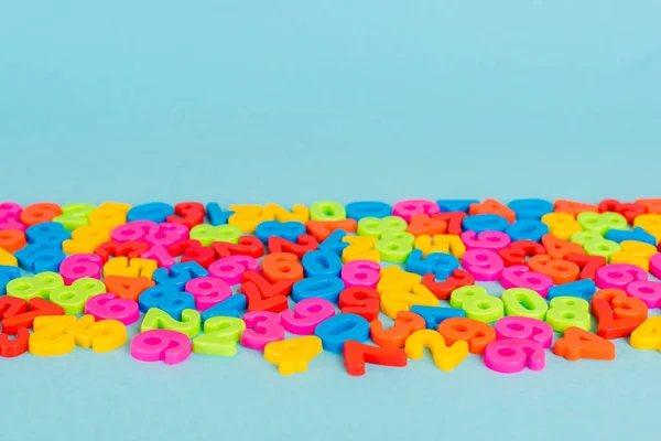Colorful plastic numbers on blue surface with copy space — Stock Photo
