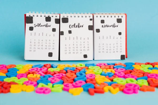 Calendrier et numéros en plastique coloré sur fond bleu — Photo de stock