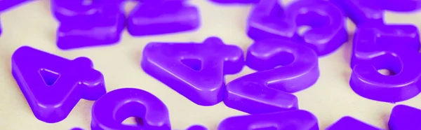 Foto panorámica de números de plástico púrpura en la superficie blanca - foto de stock