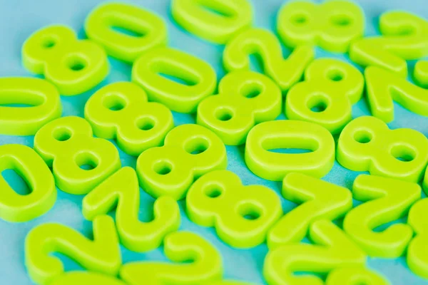 Concentration sélective des chiffres en plastique vert sur fond bleu — Photo de stock