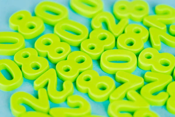 Selective focus of green plastic numbers on blue background — Stock Photo