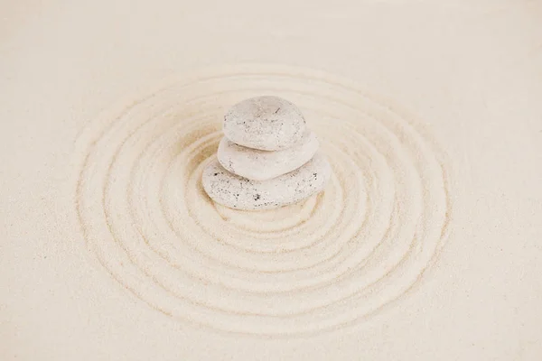 Montón de piedras zen en la superficie de arena con círculos - foto de stock
