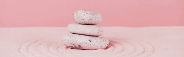 Panoramic shot of zen stones on sand surface with circles on sand on pink background — Stock Photo