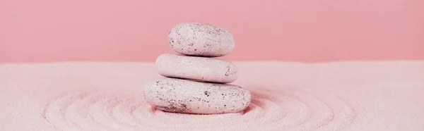 Vue panoramique de pierres zen sur la surface du sable avec des cercles sur le sable sur fond rose — Photo de stock