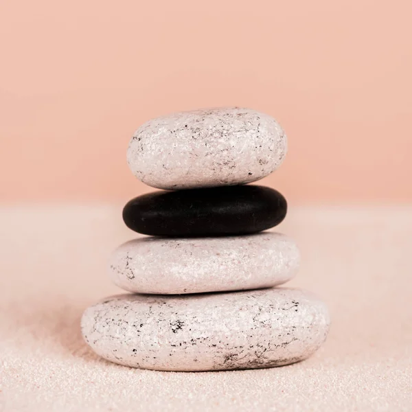 Close up view of zen stones on sand on peach background — Stock Photo