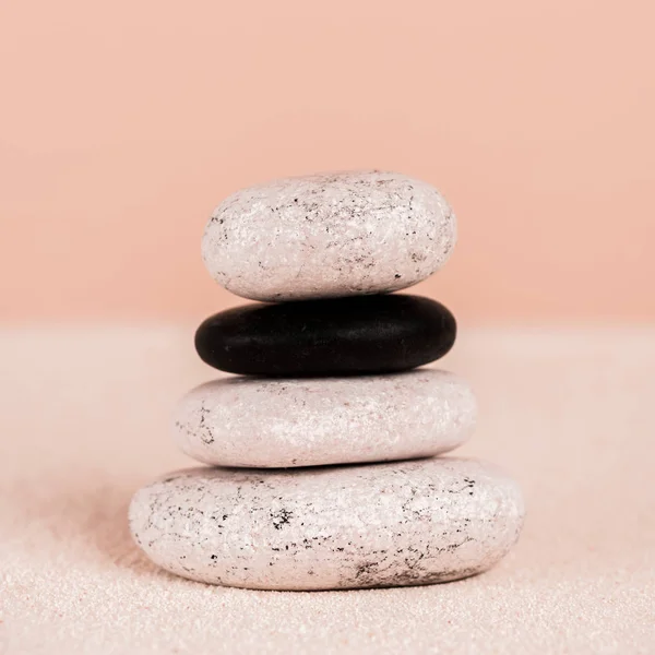 Vue rapprochée des pierres zen sur sable sur fond de pêche — Photo de stock