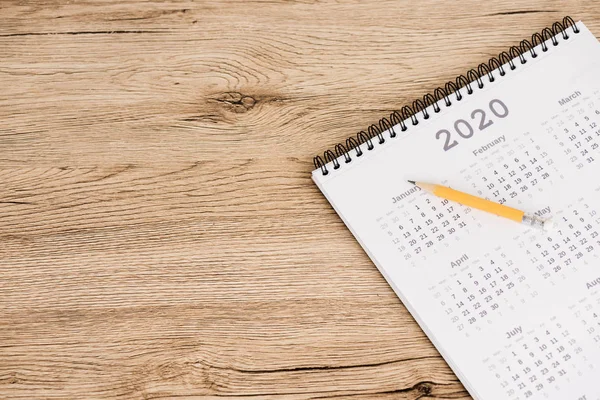 Vue grand angle du calendrier de 2020 année et crayon sur fond en bois — Photo de stock