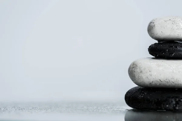 Vue rapprochée des gouttes d'eau sur pierres zen sur verre mouillé isolé sur gris — Photo de stock