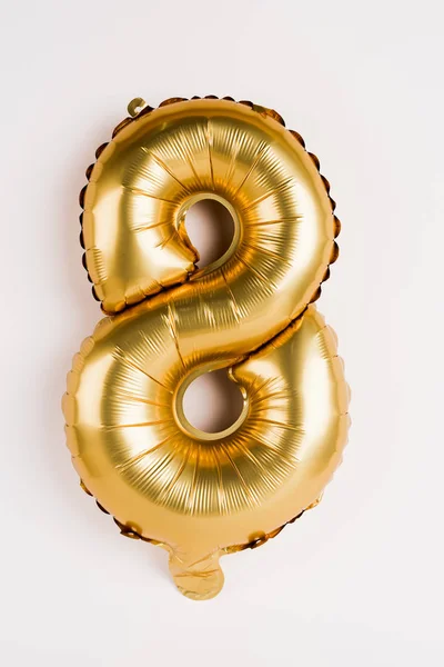 Balão dourado decorativo em forma de oito no fundo cinza — Fotografia de Stock