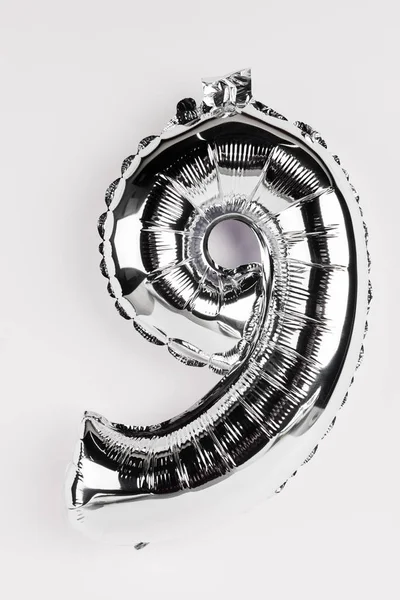 Silberner dekorativer Ballon in Form einer Neun auf grauem Hintergrund — Stockfoto