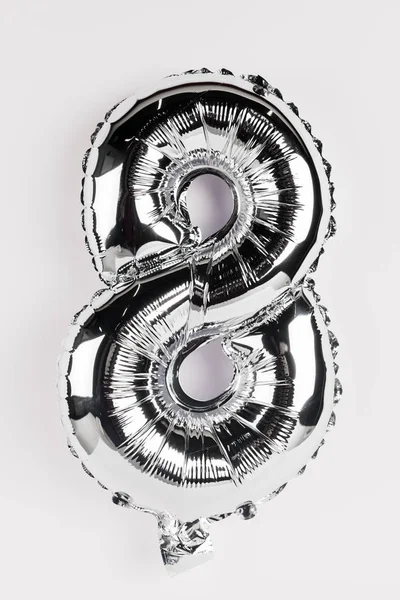 Palloncino festivo in argento a forma di otto numeri su sfondo grigio — Foto stock