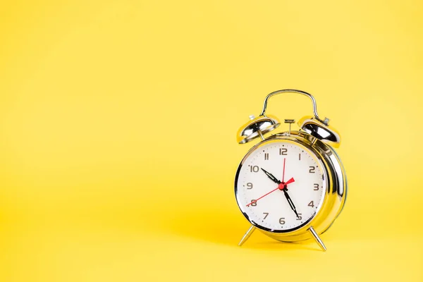 Relógio de alarme de prata no fundo amarelo — Fotografia de Stock