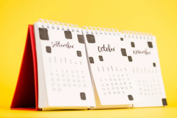 Foco selectivo de octubre en el calendario de papel sobre fondo amarillo - foto de stock