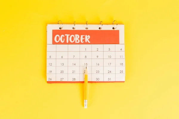 Bleistift von oben auf Kalender mit Novembermonat auf gelbem Hintergrund — Stockfoto
