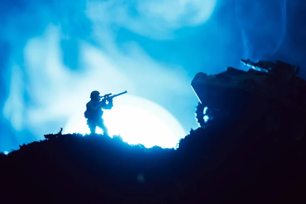 Cena de batalha com guerreiro de brinquedo e tanque com lua e fumaça no fundo — Fotografia de Stock