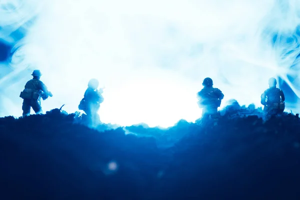 Escena de batalla con guerreros de juguete en humo sobre fondo azul - foto de stock