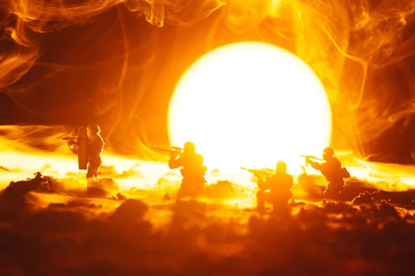 Battle scene of toy soldiers in smoke with sunset at background — Stock Photo