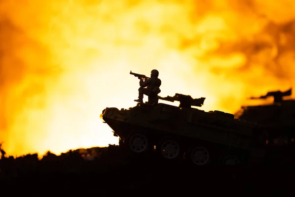 Silhouette of toy soldier on tank with fire at background, battle scene — Stock Photo