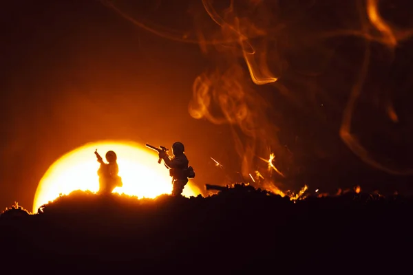 Cena de batalha com soldados de brinquedo no campo de batalha com fumaça e pôr do sol no fundo — Fotografia de Stock