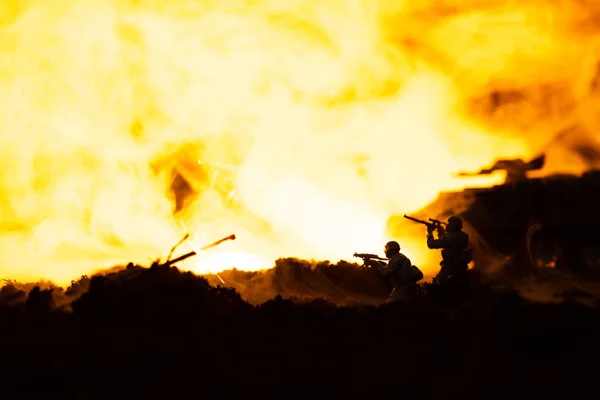 Battle scene with toy soldiers and tank on battleground with fire at background — Stock Photo