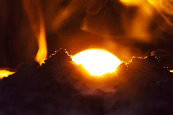 Selektiver Fokus von Erdhaufen mit Rauch und Sonnenuntergang auf schwarzem Hintergrund — Stockfoto