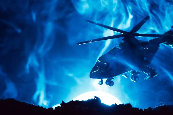Scène de bataille avec hélicoptère jouet en fumée avec lune sur fond bleu — Photo de stock
