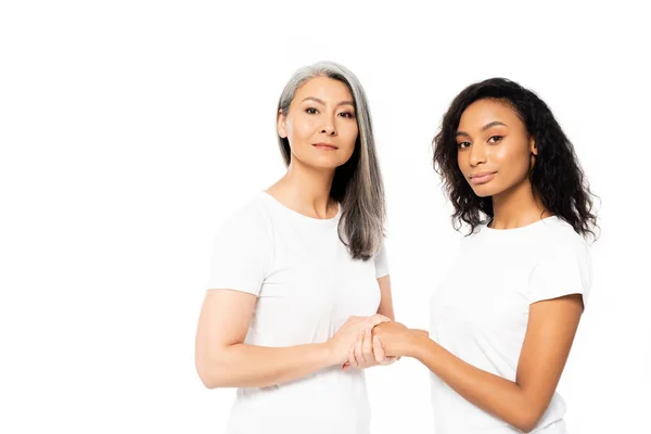 Atraente Africano americano e asiático mulheres segurando as mãos isolado no branco — Fotografia de Stock