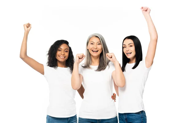 Mulheres multiculturais sorridentes com as mãos acima da cabeça comemorando isolado em branco — Fotografia de Stock