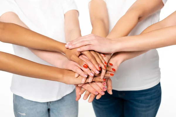 Cropped view of four multicultural women putting hands together isolated on white — Stock Photo