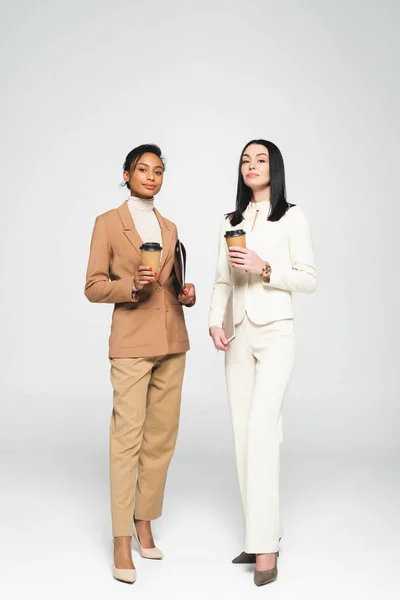 Donne d'affari multiculturali che tengono bicchieri di carta su bianco — Foto stock
