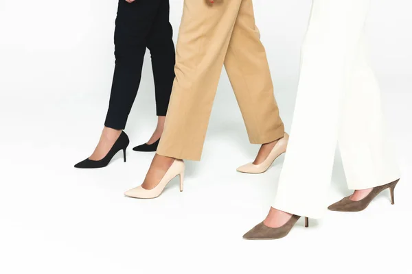 Cropped view of multicultural businesswoman walking on white — Stock Photo