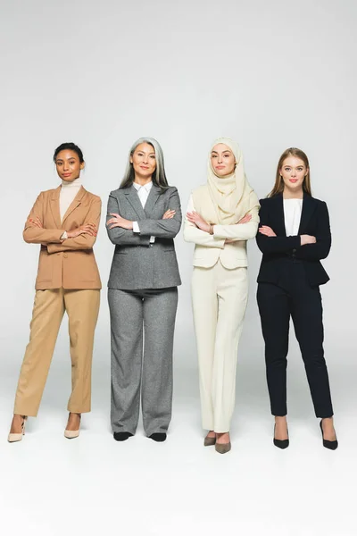 Belles femmes multiculturelles debout avec les bras croisés sur blanc — Photo de stock