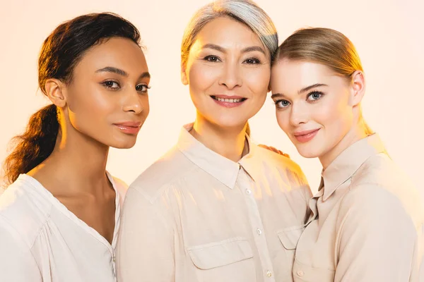 Trois belles femmes multiculturelles souriantes isolées sur beige — Photo de stock