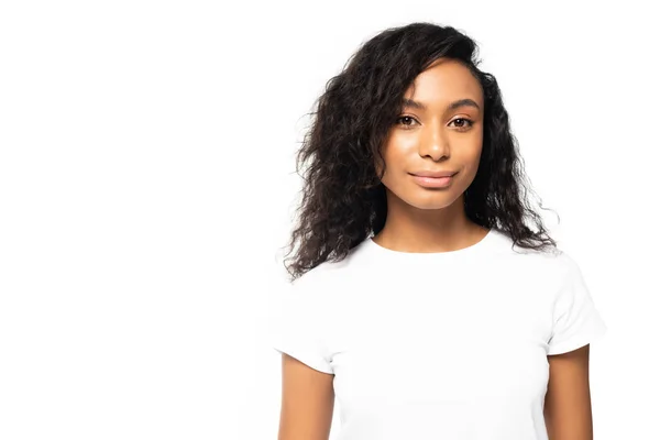 Sonriente mujer afroamericana en camiseta blanca mirando a la cámara aislada en blanco - foto de stock