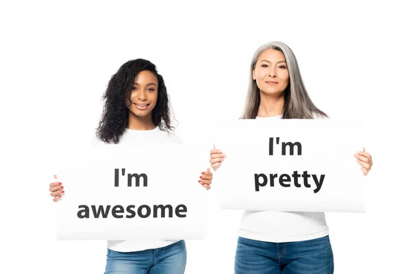 Fröhliche afrikanisch-amerikanische und asiatische Frauen mit Plakaten mit Schriftzug auf weißem Grund — Stockfoto