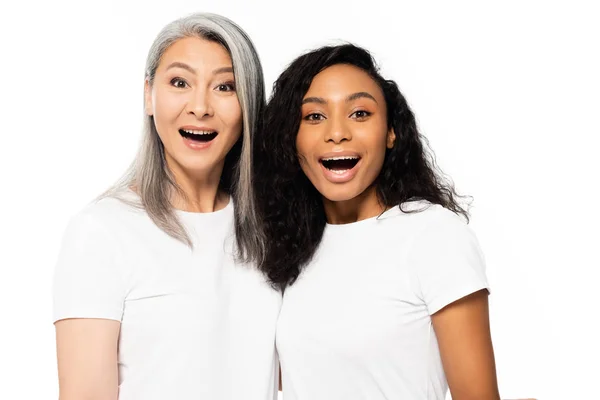 Sorprendido africano americano y asiático mujeres mirando cámara aislado en blanco - foto de stock