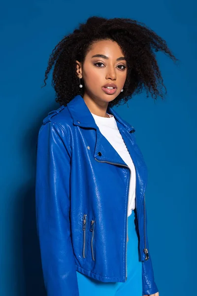 Hermosa mujer afroamericana mirando a la cámara sobre fondo azul - foto de stock