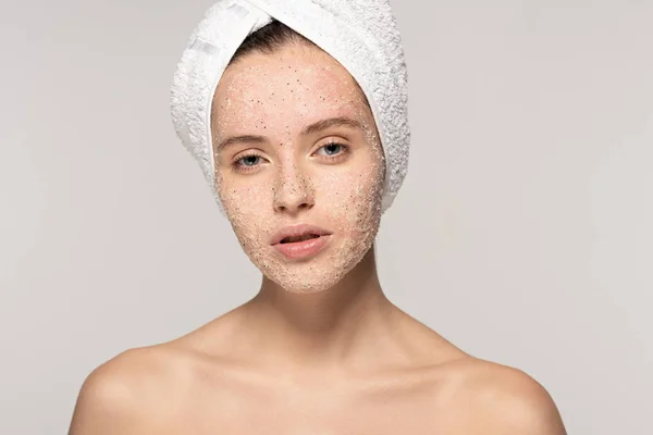 Jolie fille avec gommage de noix de coco sur le visage et serviette sur la tête, isolé sur gris — Photo de stock