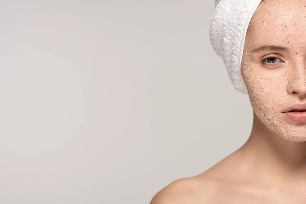 Beautiful girl with coconut scrub on face and towel on head, isolated on grey — Stock Photo