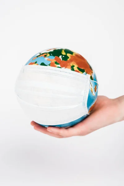 Cropped view of woman holding globe in medical mask isolated on white — Stock Photo