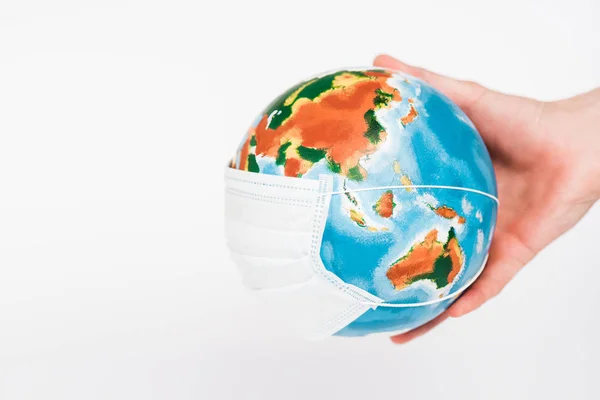 Cropped view of man holding globe in protective mask isolated on white — Stock Photo